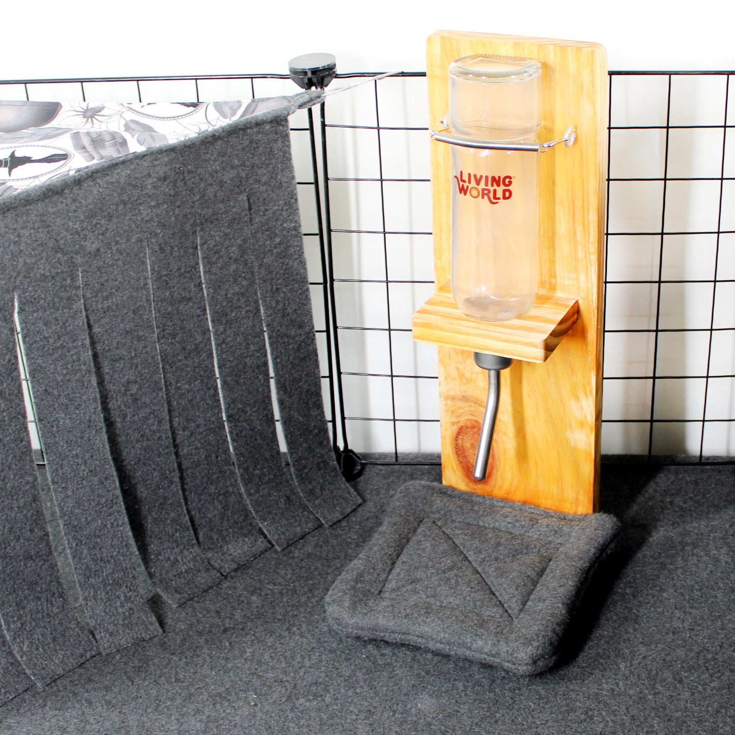 Gray pet mat with a wooden pet stand and glass on a tiled floor.