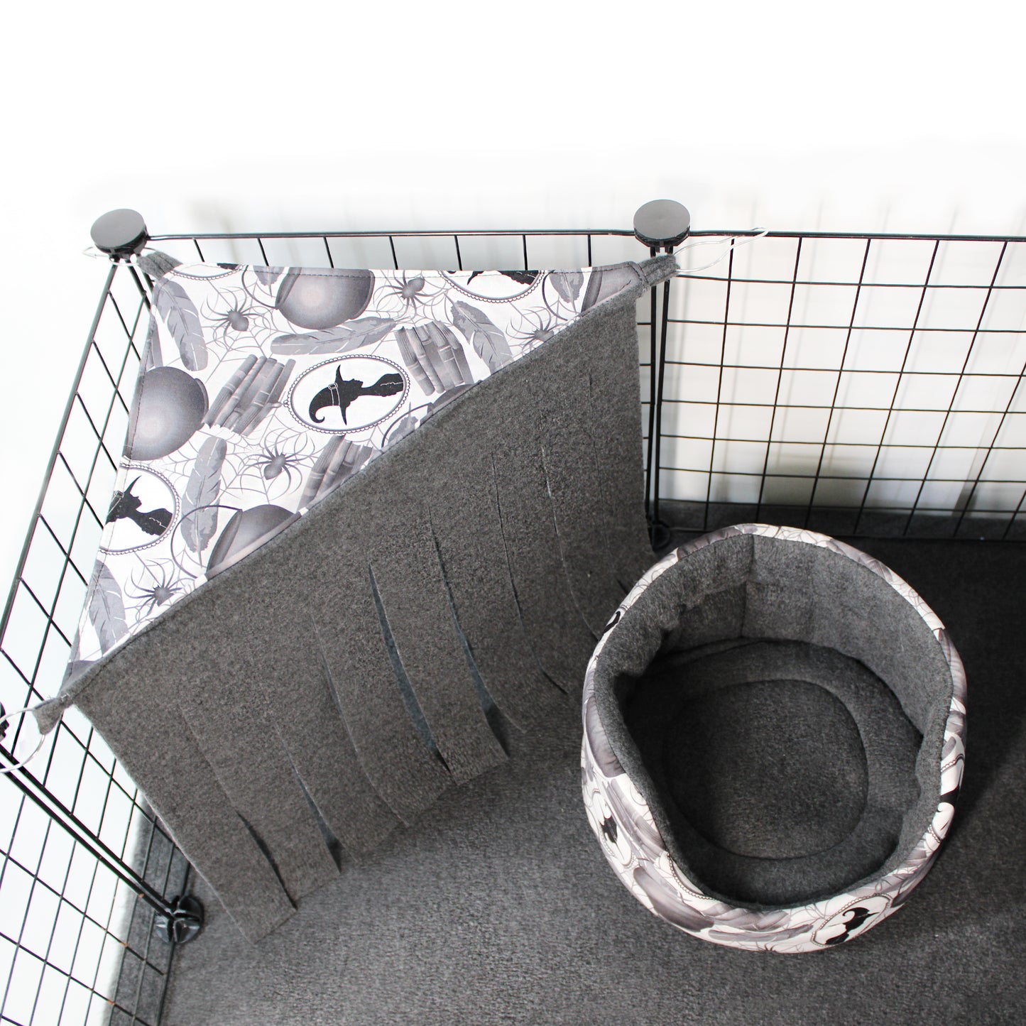 Cat bed with a patterned mat inside a wire cage