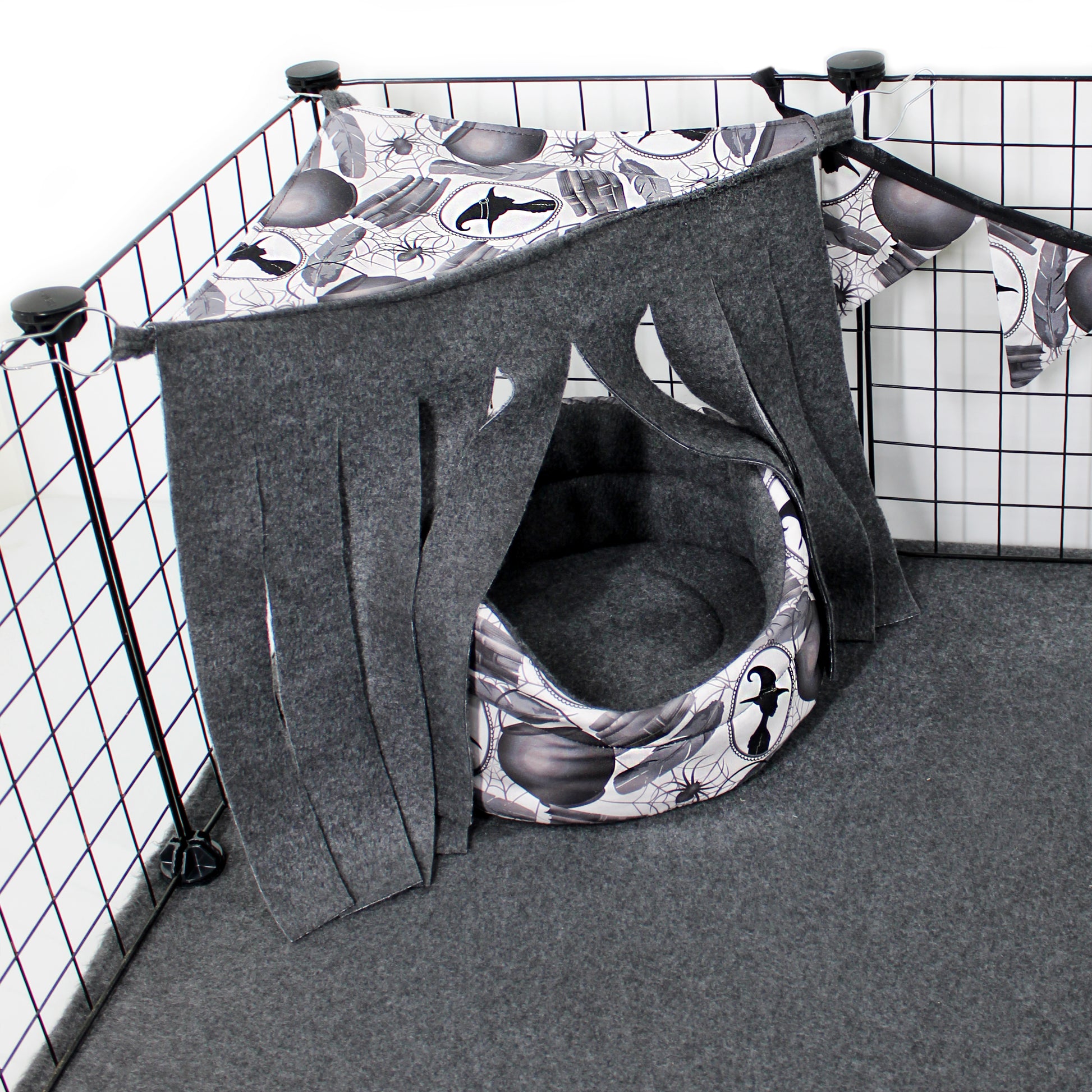 Pet playpen with a gray and black patterned tent inside, on a grid background.