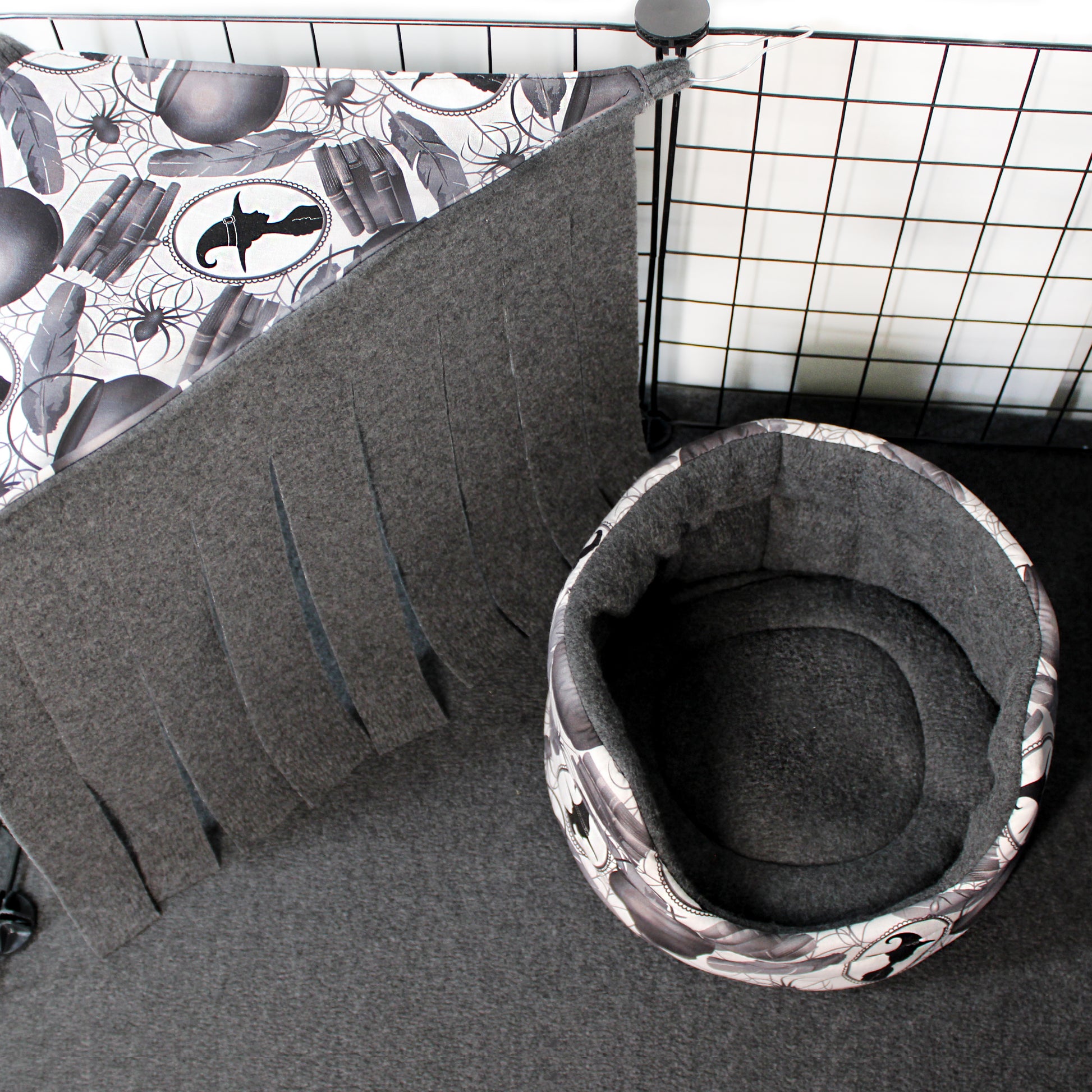 Gray pet bed with a patterned cover on a grid background