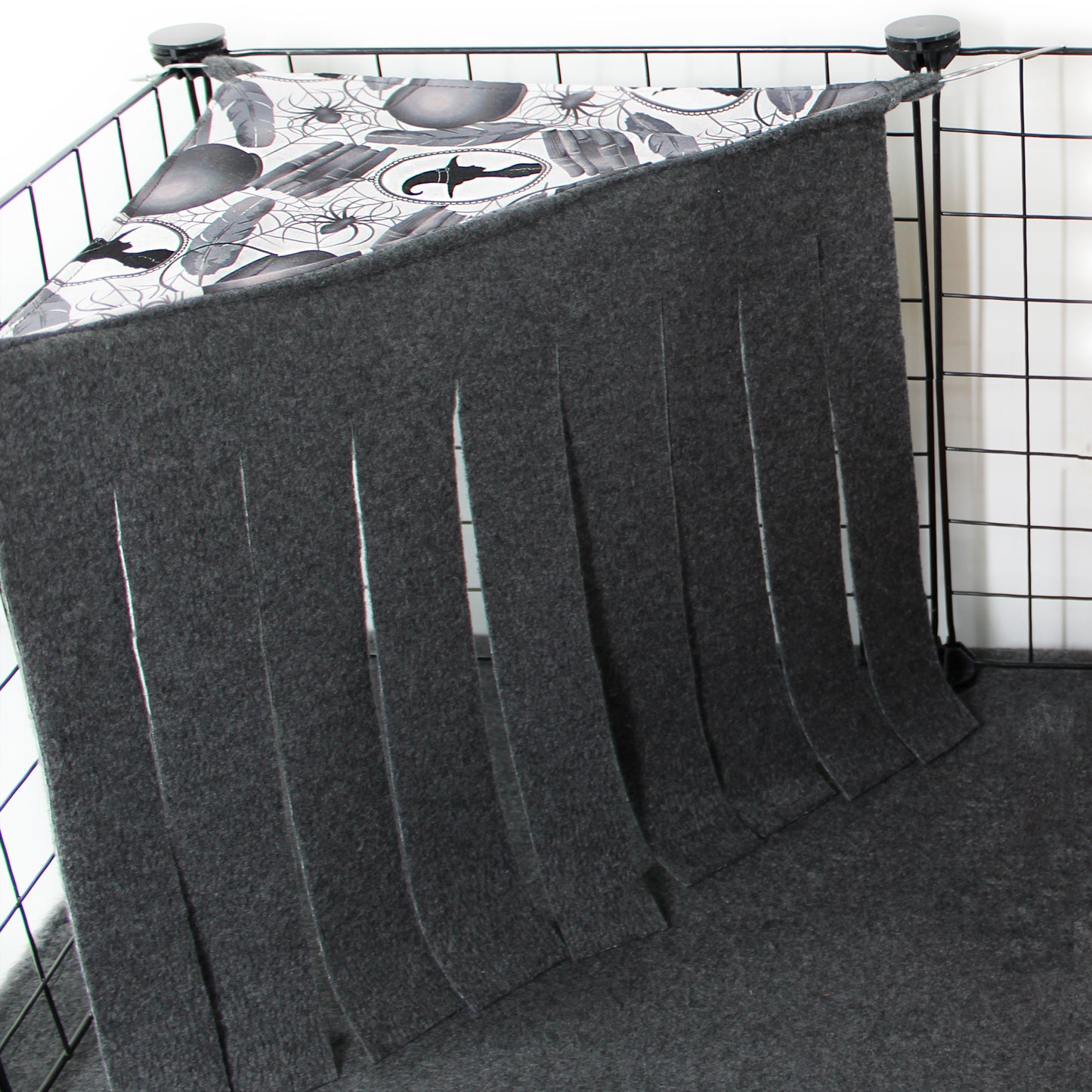 Gray pet crate cover with a patterned top on a wire crate.