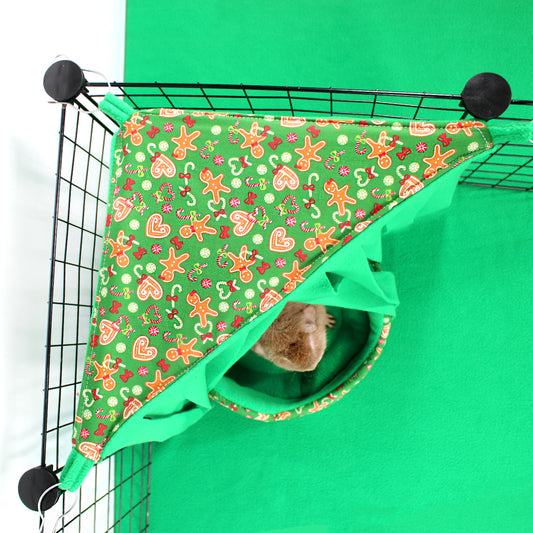 Pet cage with a green and red patterned cover and a small animal peeking out.