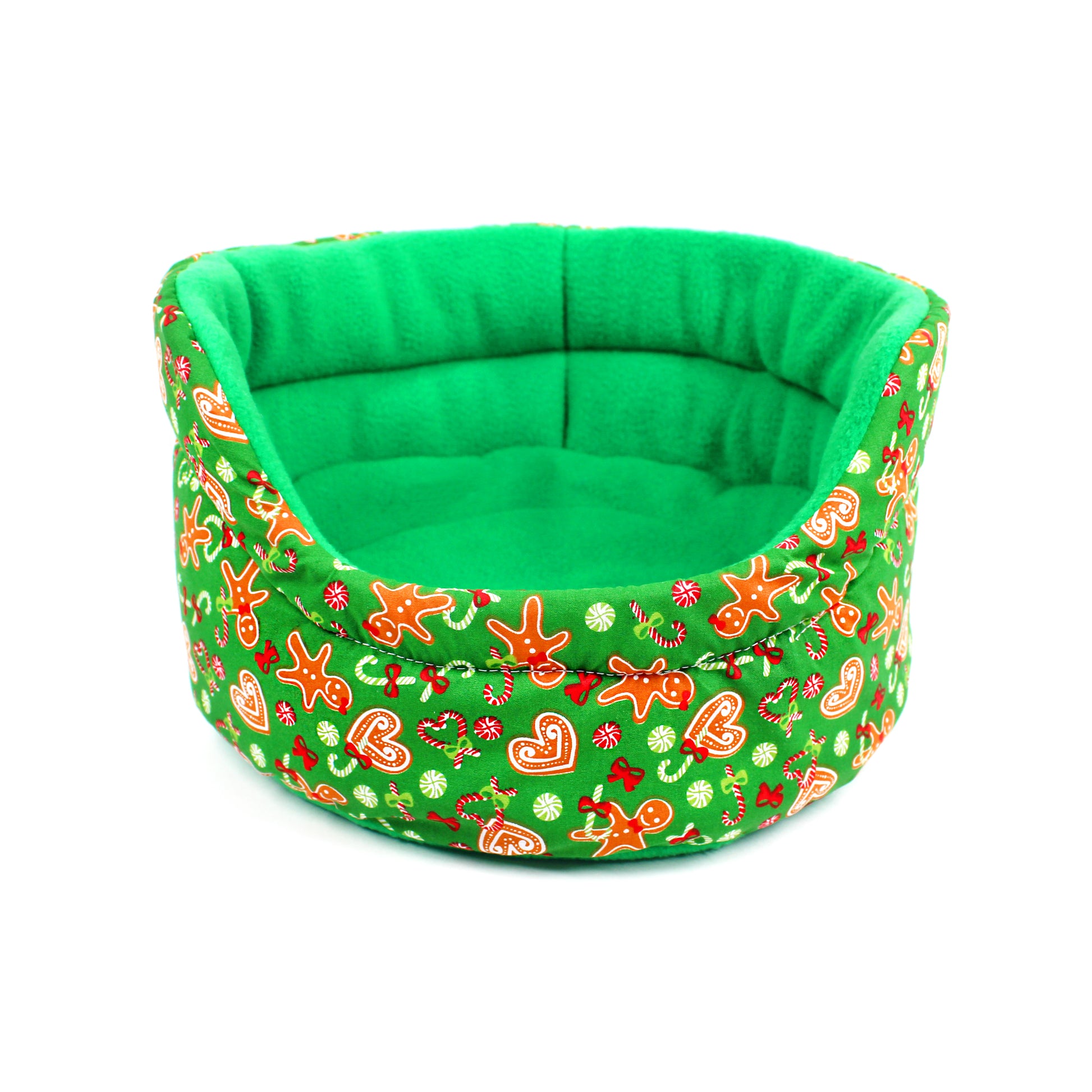 Green pet bed with festive gingerbread pattern on a white background