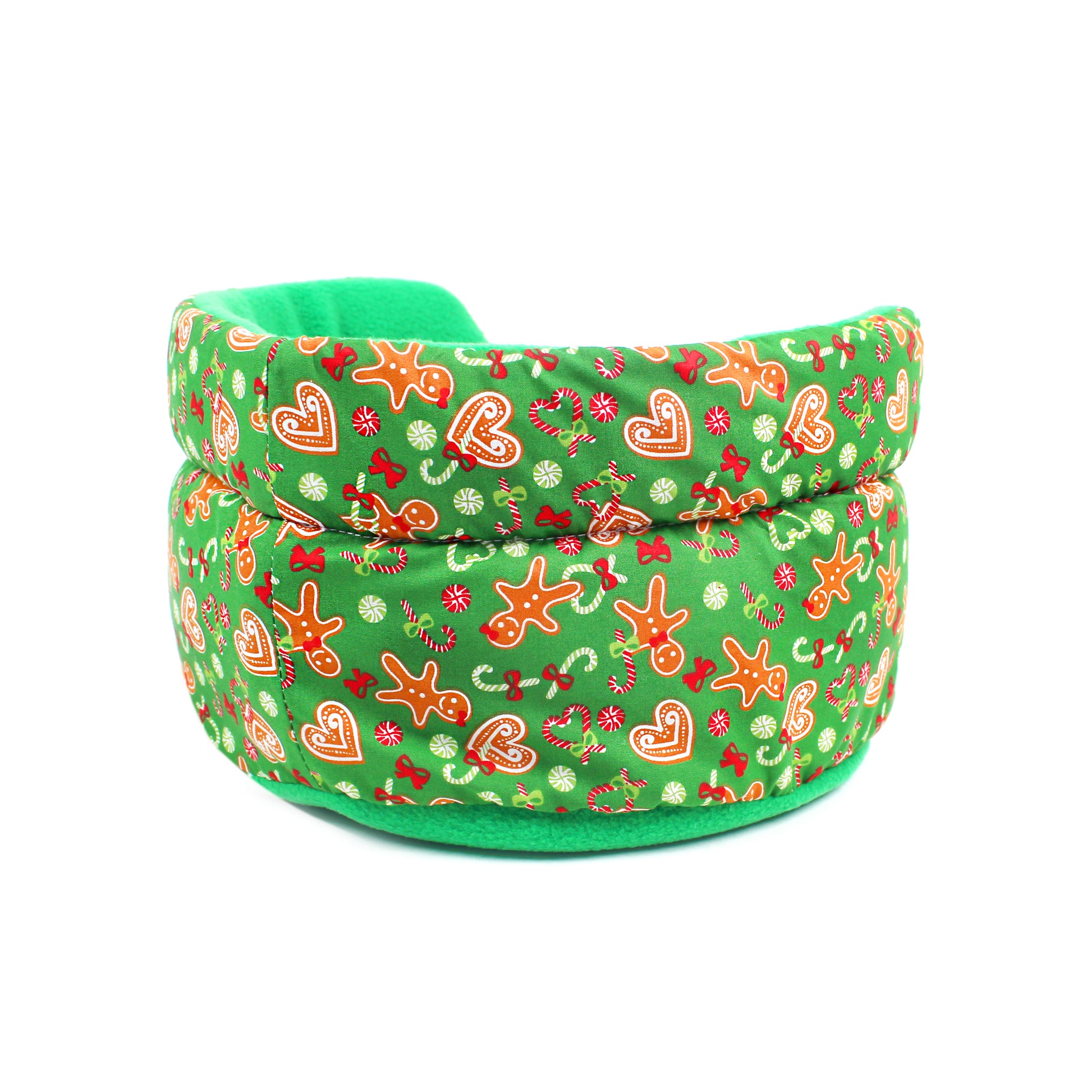 Green fabric pet bed with festive gingerbread pattern on a white background