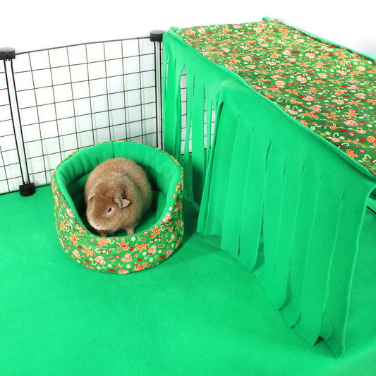 Small animal in a floral-patterned bed inside a green pet enclosure with a floral curtain.