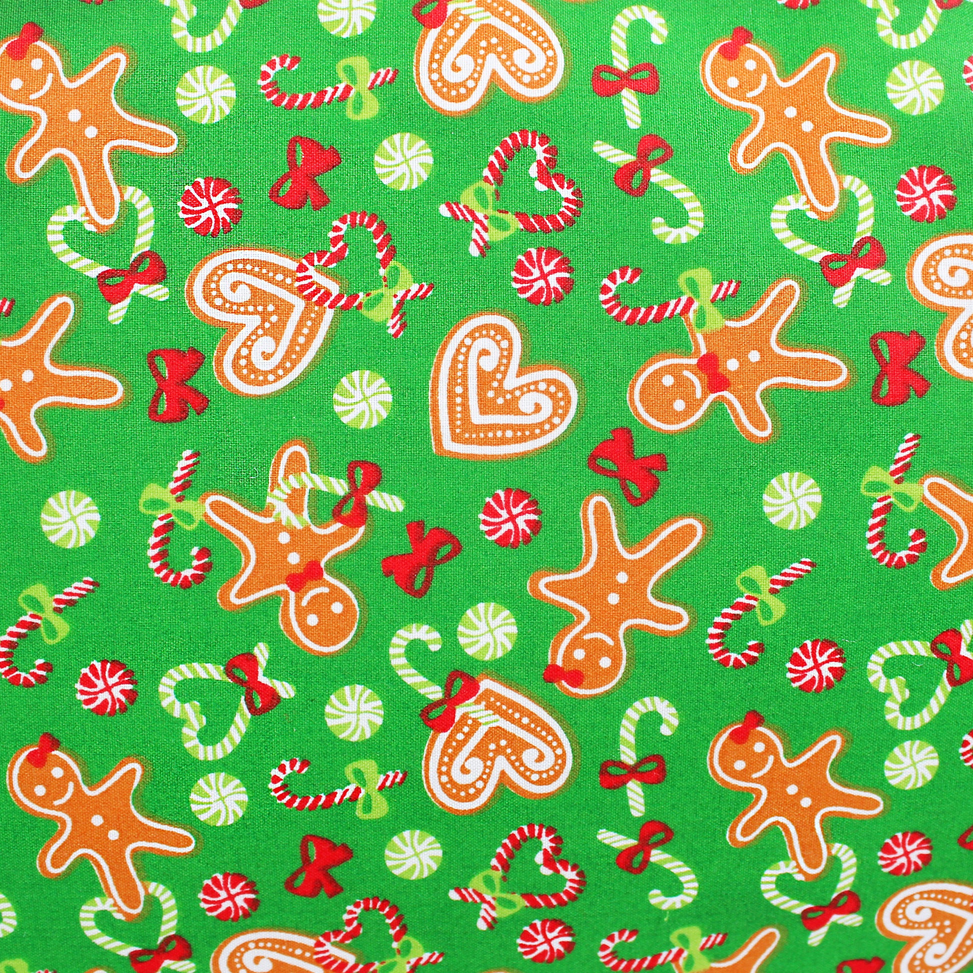 Christmas-themed fabric pattern with gingerbread men, candy canes, and bows on a green background.