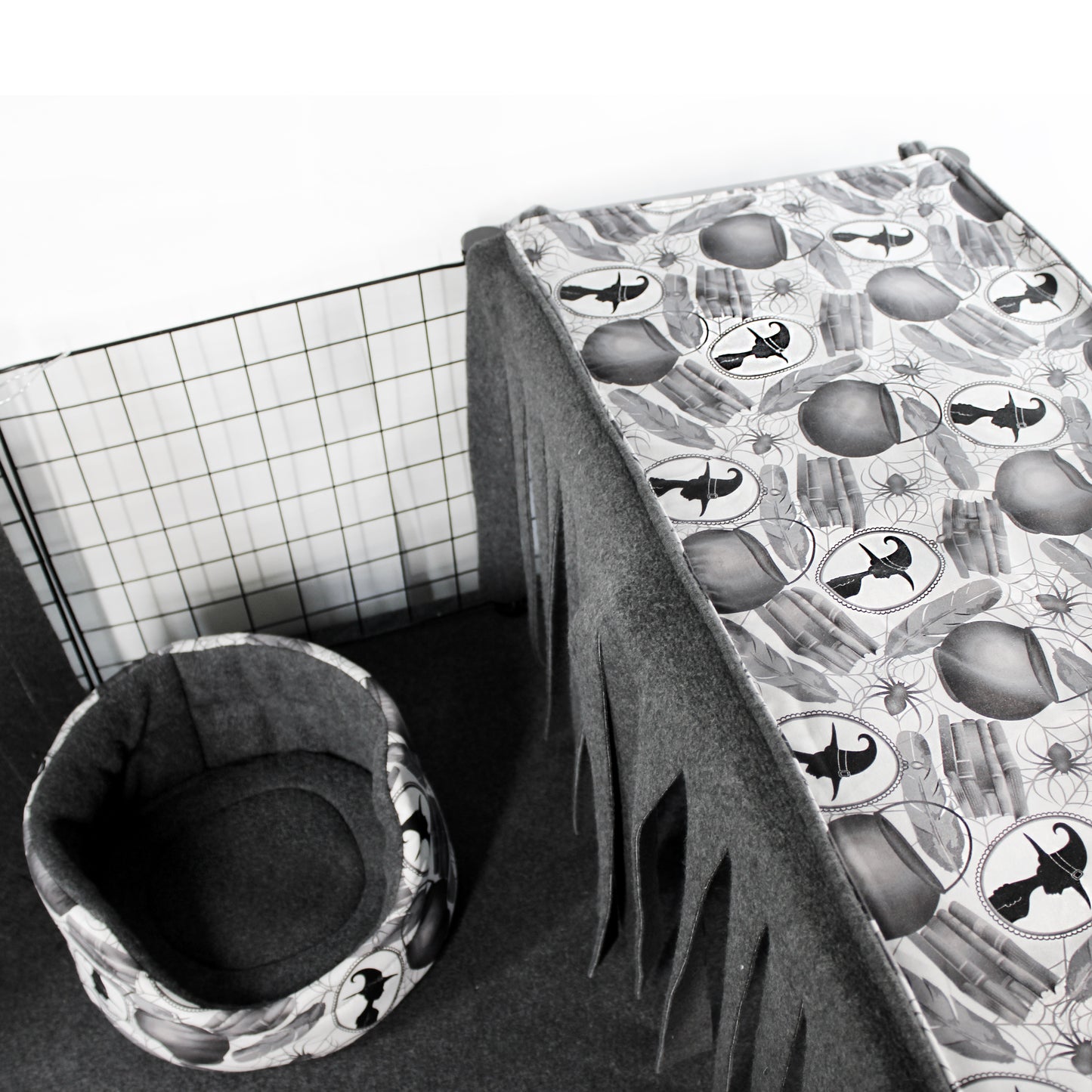 Pet cage with a patterned cover and a cushioned pet bed on a white background