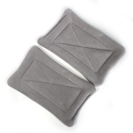 Two gray pee mats with geometric patterns on a white background
