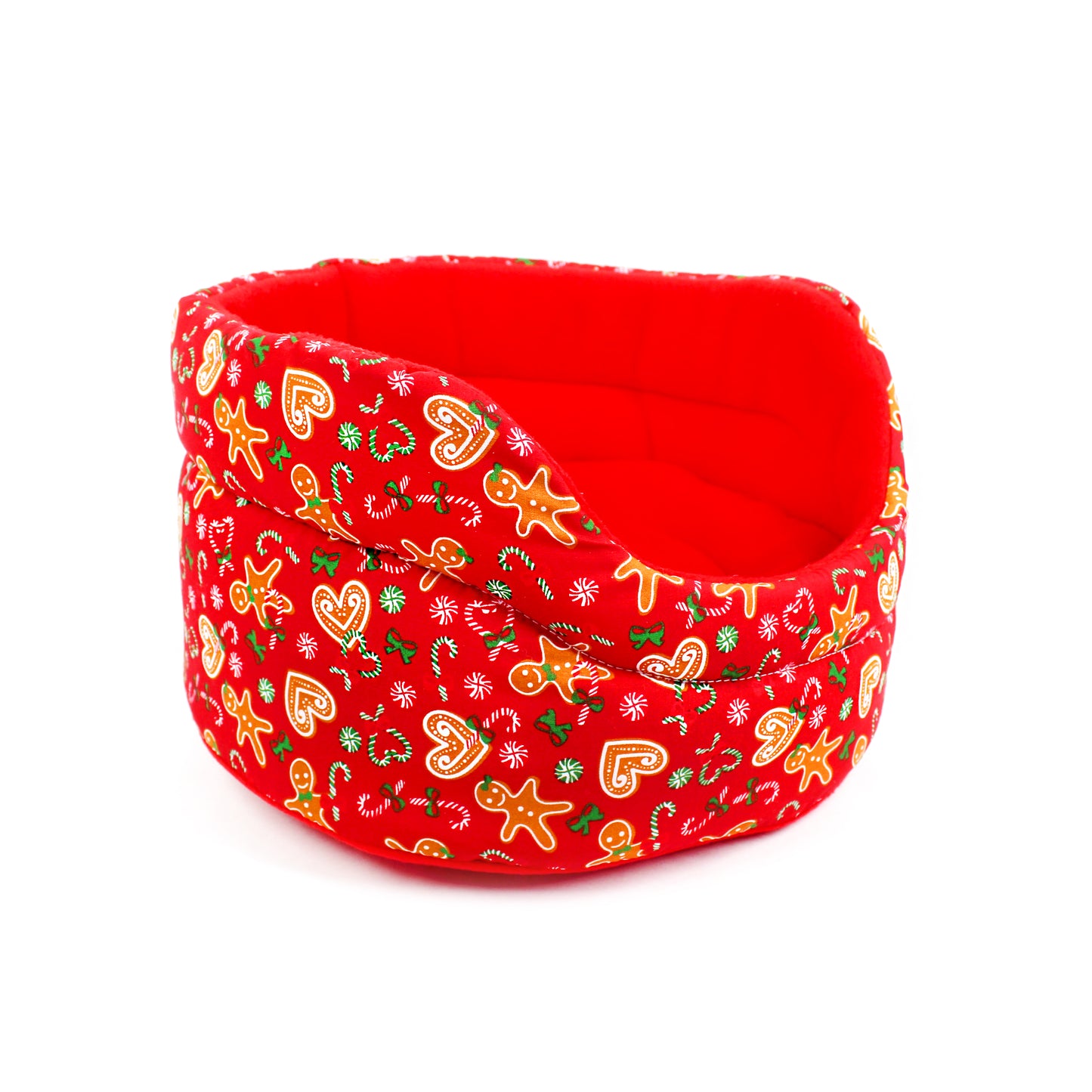 Red fabric pet bed with Christmas-themed pattern on a white background