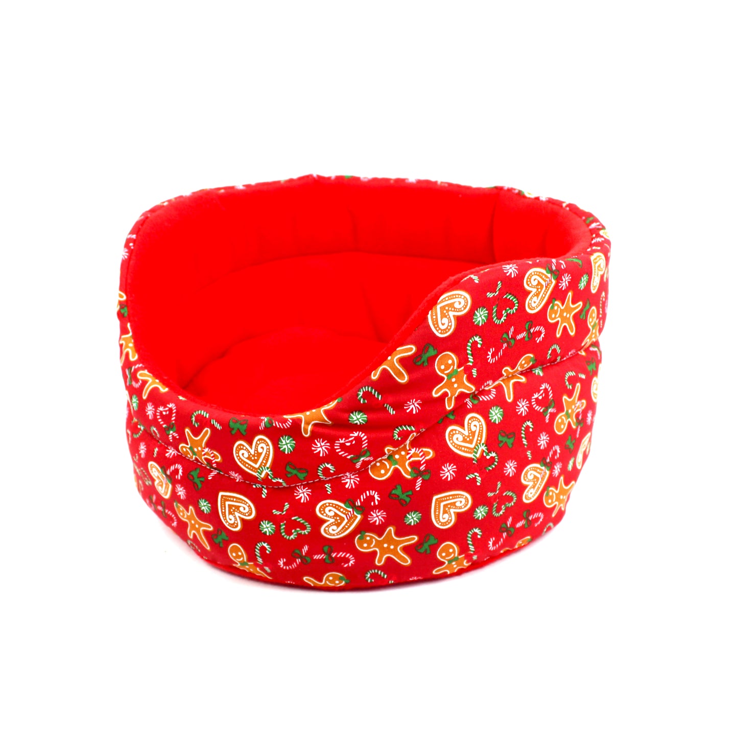 Red pet bed with Christmas-themed pattern on a white background