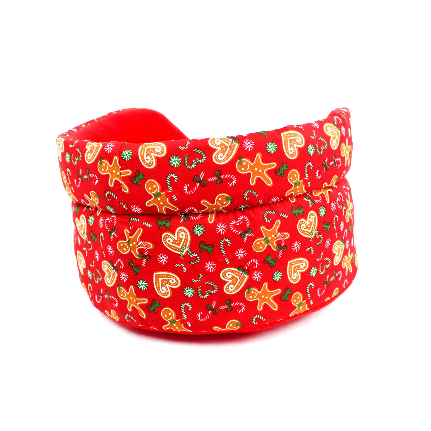 Red pet bed with Christmas-themed pattern on a white background