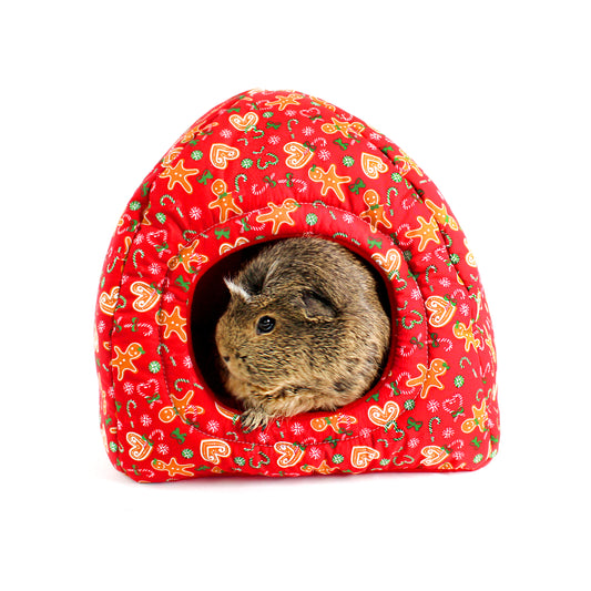 Small animal peeking out from a red patterned pet house on a white background
