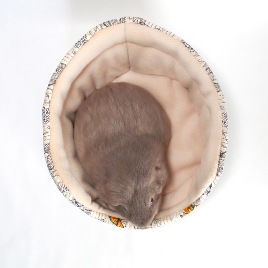 Steampunk Butterfly Cuddle Cup Bed, top view with a cosy guinea pig resting inside the bed for guinea pigs