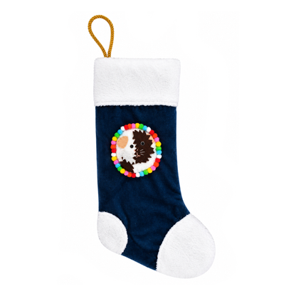 Handmade brown and white Abyssinian guinea pig Christmas stocking with spiky felt guinea pig decoration, navy blue recycled velvet, soft white cuddle fleece trim, colourful pom-poms and gold rope hanging loop.