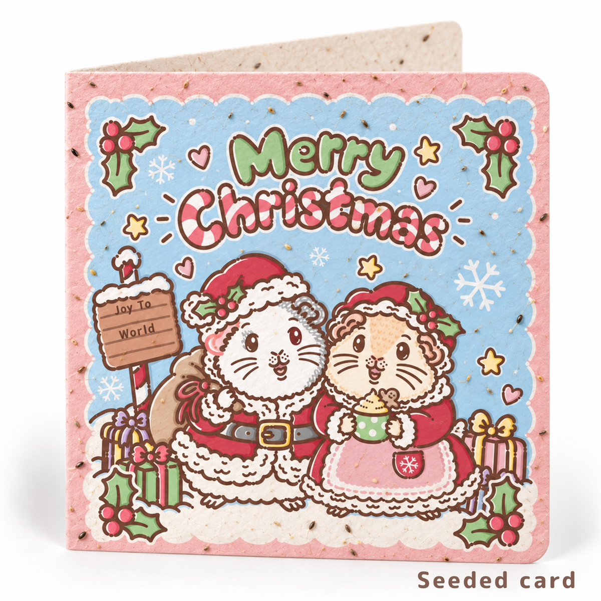 Seeded Christmas guinea pig card featuring Mr Whippy and Halloumi dressed as Mr and Mrs Claus, with visible seeds in the paper