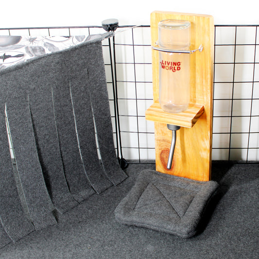 Gray pet mat with a wooden pet stand and glass on a tiled floor.