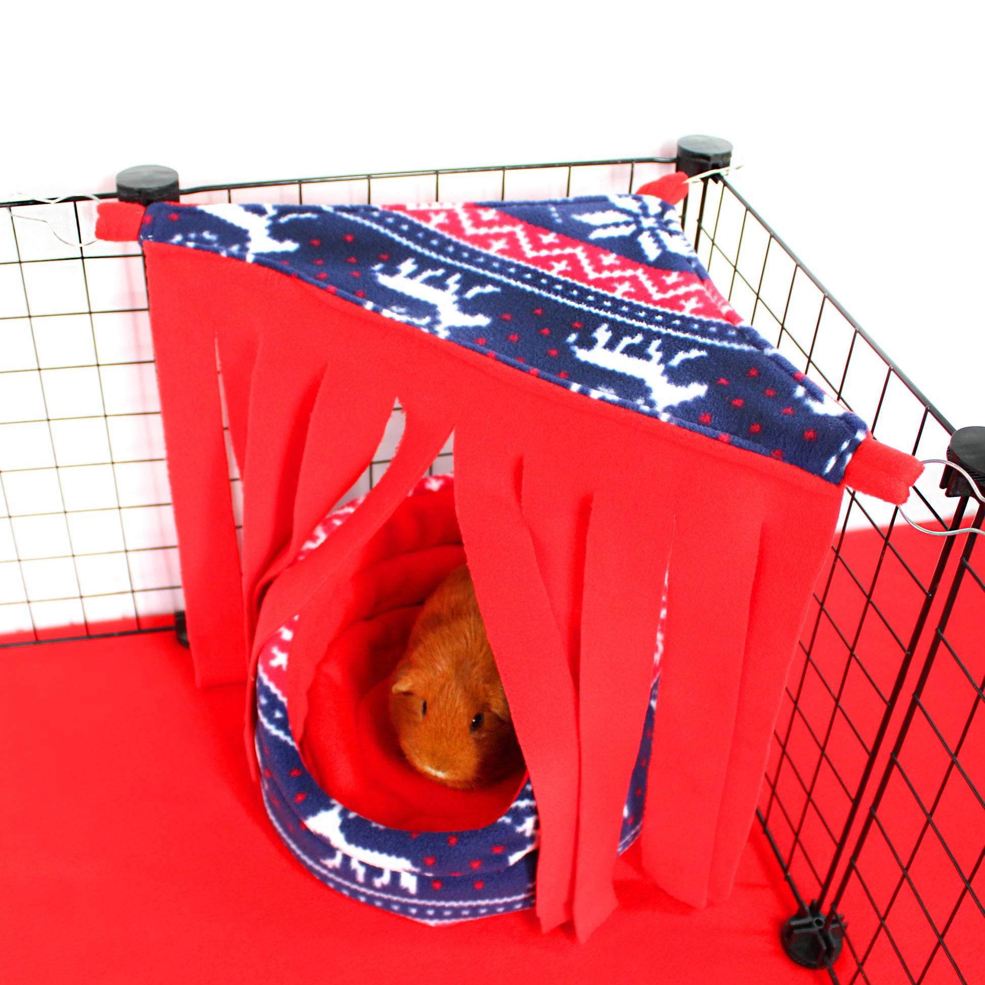 Pet cage with red and blue patterned cover and circular bed inside