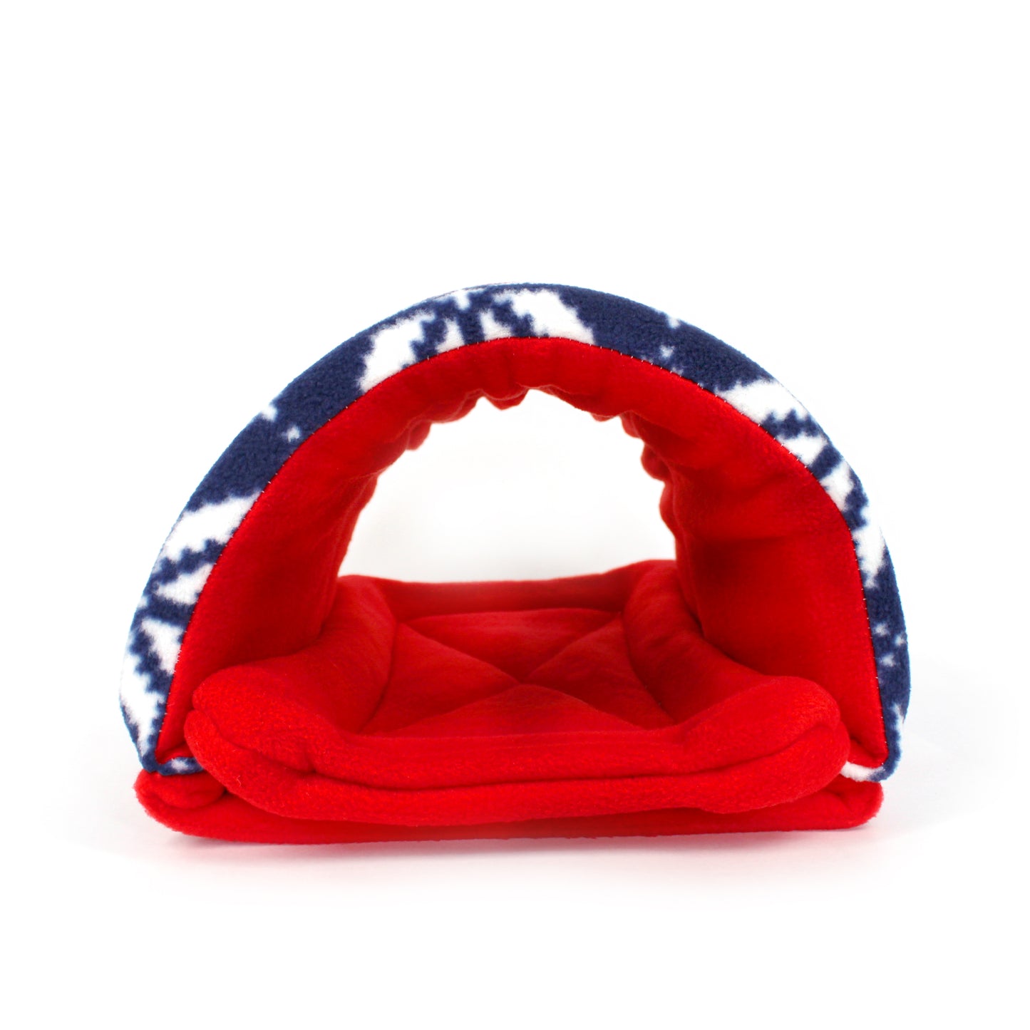 Red pet bed with blue and white tie-dye cover on a white background