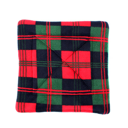 Folded plaid blanket with red, green, and black colours on a white background