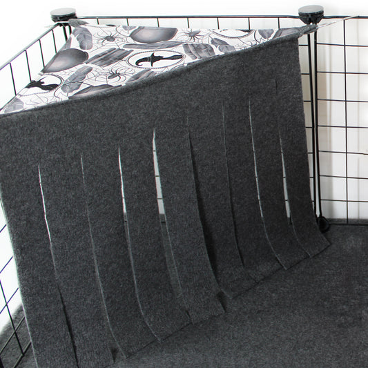 Gray pet crate cover with a patterned top on a wire crate.