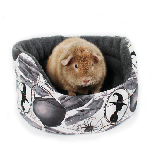 Small animal in a patterned pet bed with Halloween design