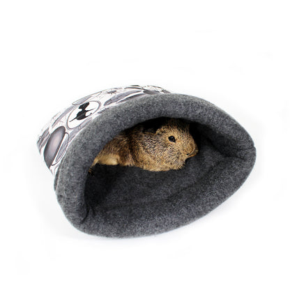 Small animal peeking out from a gray felted pet cave with a white background