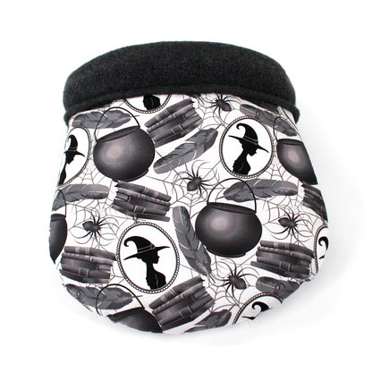 cuddle sack with a Halloween-themed pattern featuring witches, cauldrons, and books on a white background.