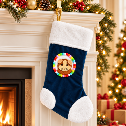 Ginger and cream guinea pig Christmas stocking hanging beside a decorated Christmas fireplace, featuring a handmade felt guinea pig design, navy blue velvet, fluffy white trim, colourful pom-poms and gold rope hanging loop.