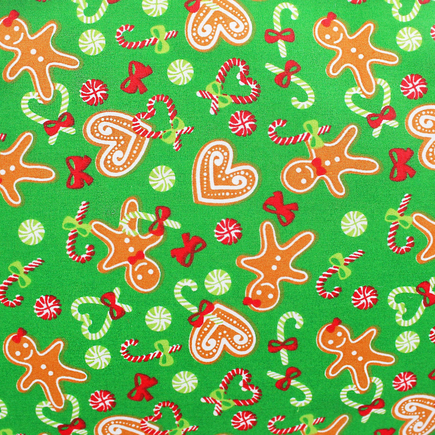 Christmas-themed fabric pattern with gingerbread men, candy canes, and bows on a green background.