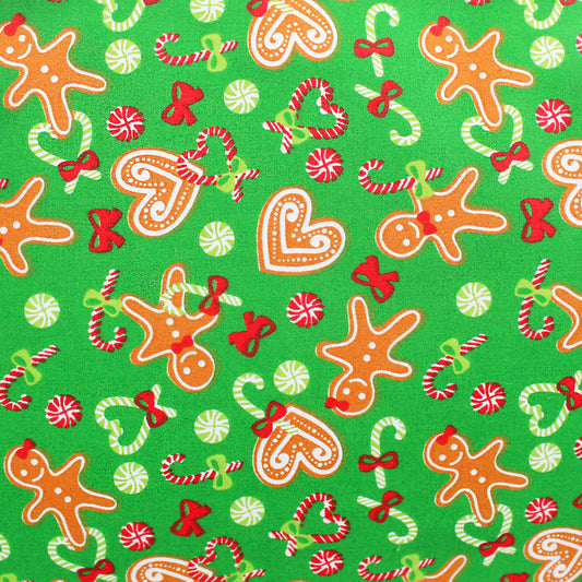 Christmas-themed fabric pattern with gingerbread men, candy canes, and bows on a green background.