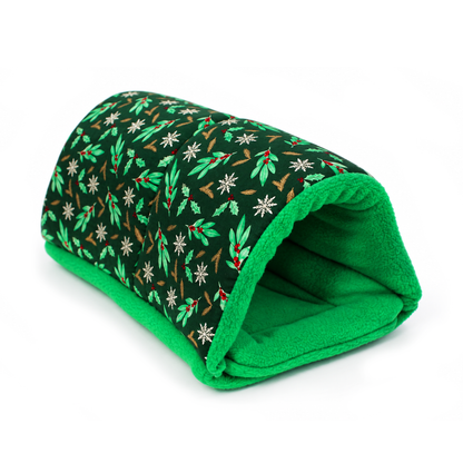 Side view of a handmade guinea pig snuggle tunnel in forest green Christmas cotton with holly, berries, snowflakes and gold foliag