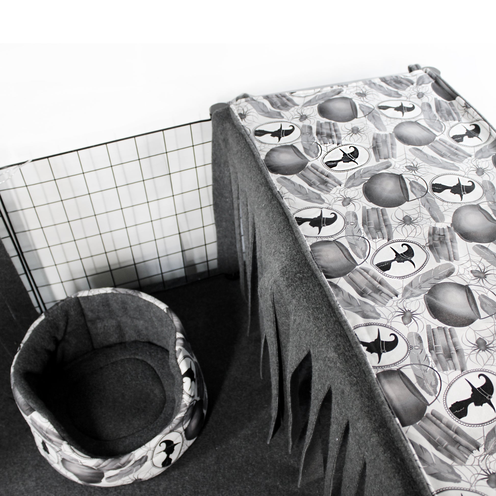 Pet cage with a patterned cover and a cushioned pet bed on a white background