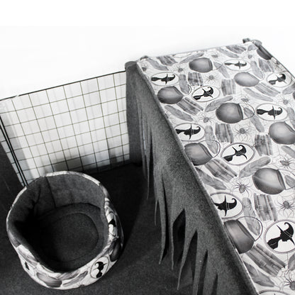 Pet cage with a patterned cover and a cushioned pet bed on a white background