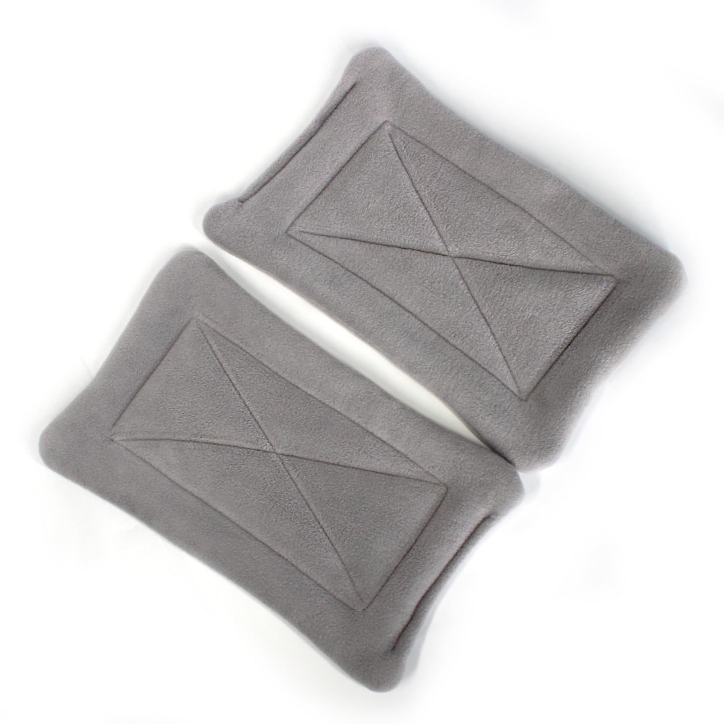 Two gray pee mats with geometric patterns on a white background