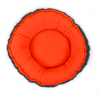 Round orange cushion with black rim on a white background