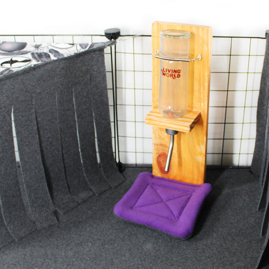 Wooden water bottle stand with a purple drip pad on a tiled wall background