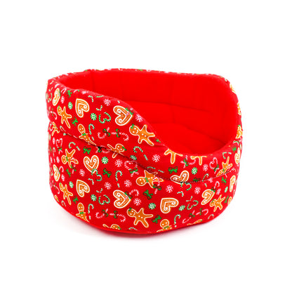 Red fabric pet bed with Christmas-themed pattern on a white background