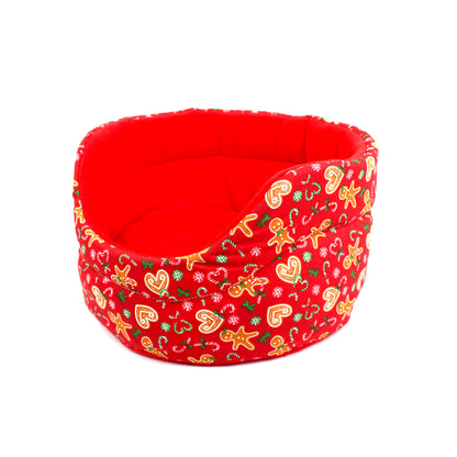 Red pet bed with Christmas-themed pattern on a white background