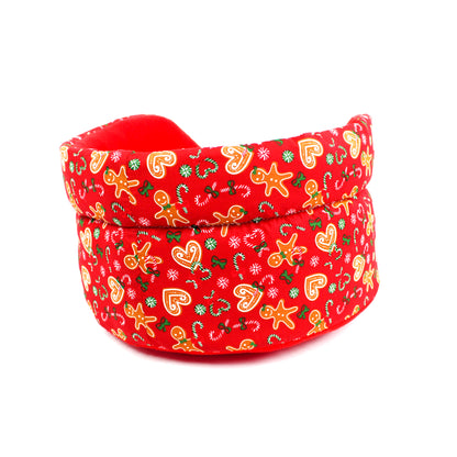 Red pet bed with Christmas-themed pattern on a white background