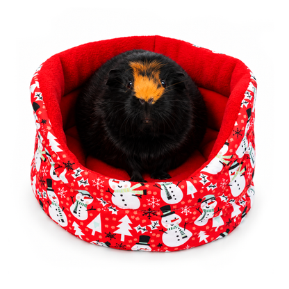 Red snowman Christmas cuddle cup bed for guinea pigs with red anti-pill fleece lining and a festive cotton outer featuring snowmen, snowflakes and Christmas trees, modelled by Olive