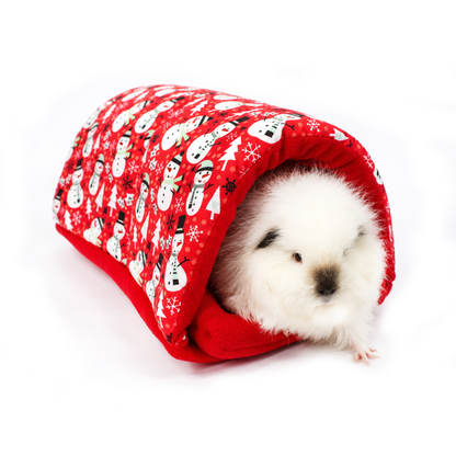Swiss Roll the guinea pig peeking out of a red Christmas squish tunnel decorated with snowmen, snowflakes and Christmas trees