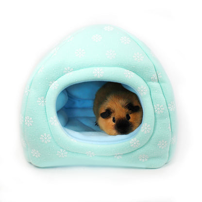 Small animal peeking out from a light blue pet house with snowflake pattern on a white background