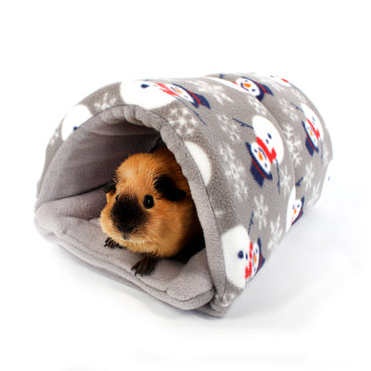 Small animal peeking out from a gray fleece tunnel with penguin pattern on a white background