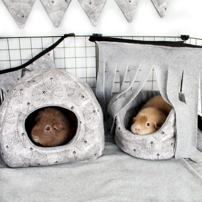 Halloween Spider Accessories, showing the hidey house and cuddle cup bed in a cage set up with happy relaxed guinea pigs