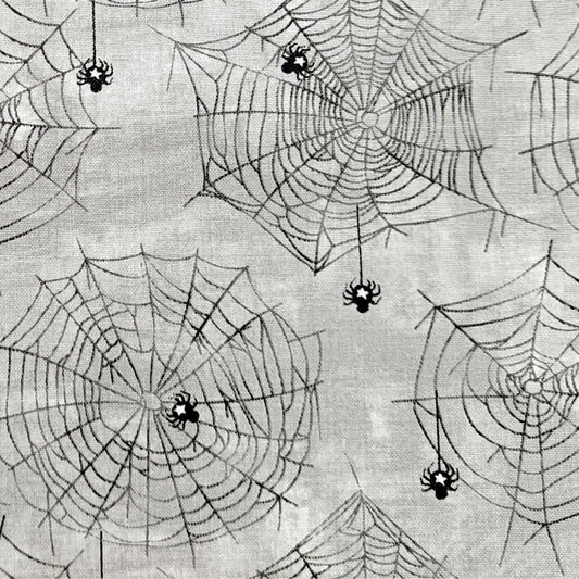 Halloween Spider Fabric, Close up of the cotton material showing the Subtle spider and web design on a grey background